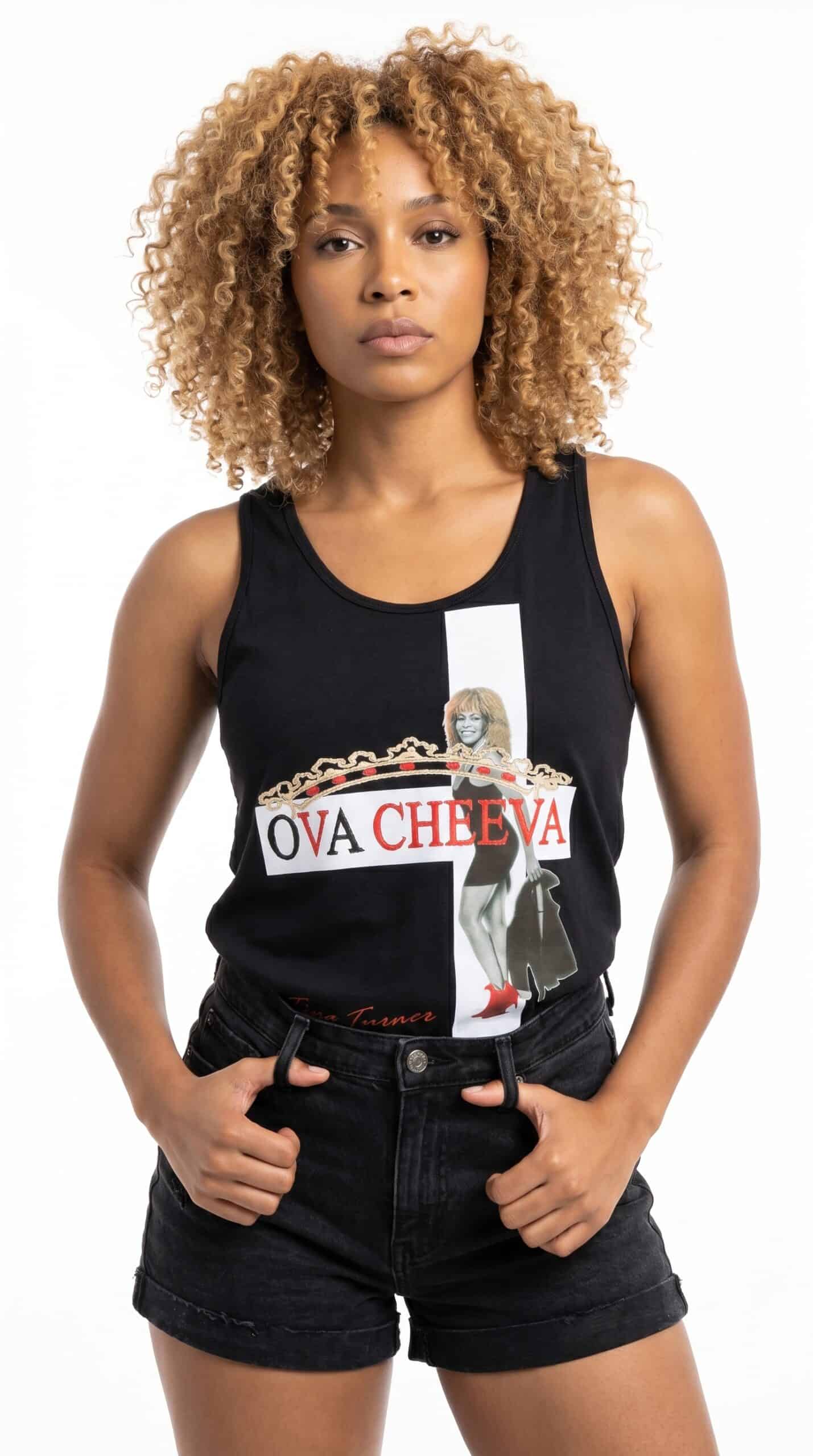 A woman with curly blonde hair wearing a black tank top featuring a graphic design and the text "OVA.