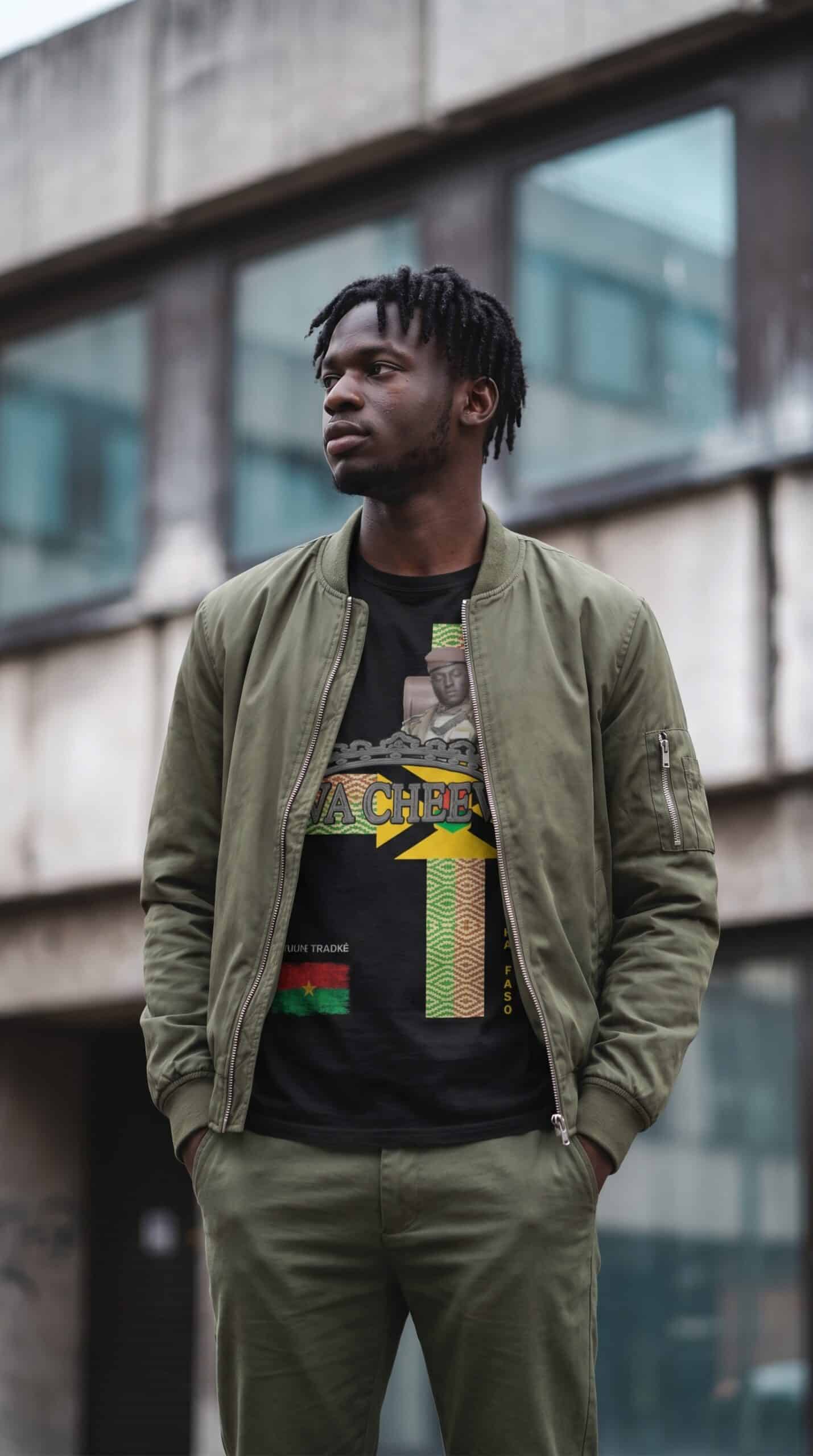 Young man in urban streetwear standing outside modern building, casual style.