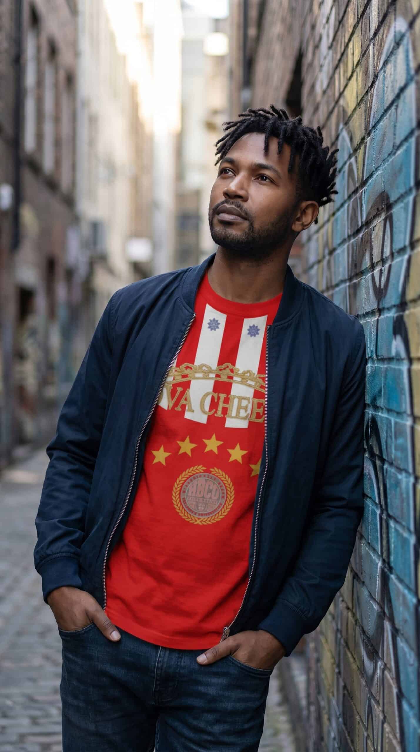 Urban man standing in alleyway wearing casual streetwear and a graphic T-shirt.