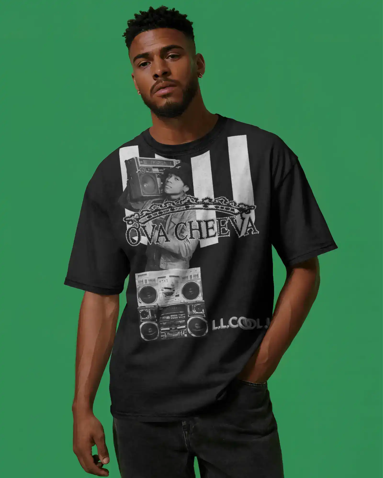 A man stands against a green background wearing a black graphic T-shirt featuring a boombox, a chain, and OVA CHEEVA text, along with “LL COOL J” at the bottom. He has short hair and a trimmed beard.