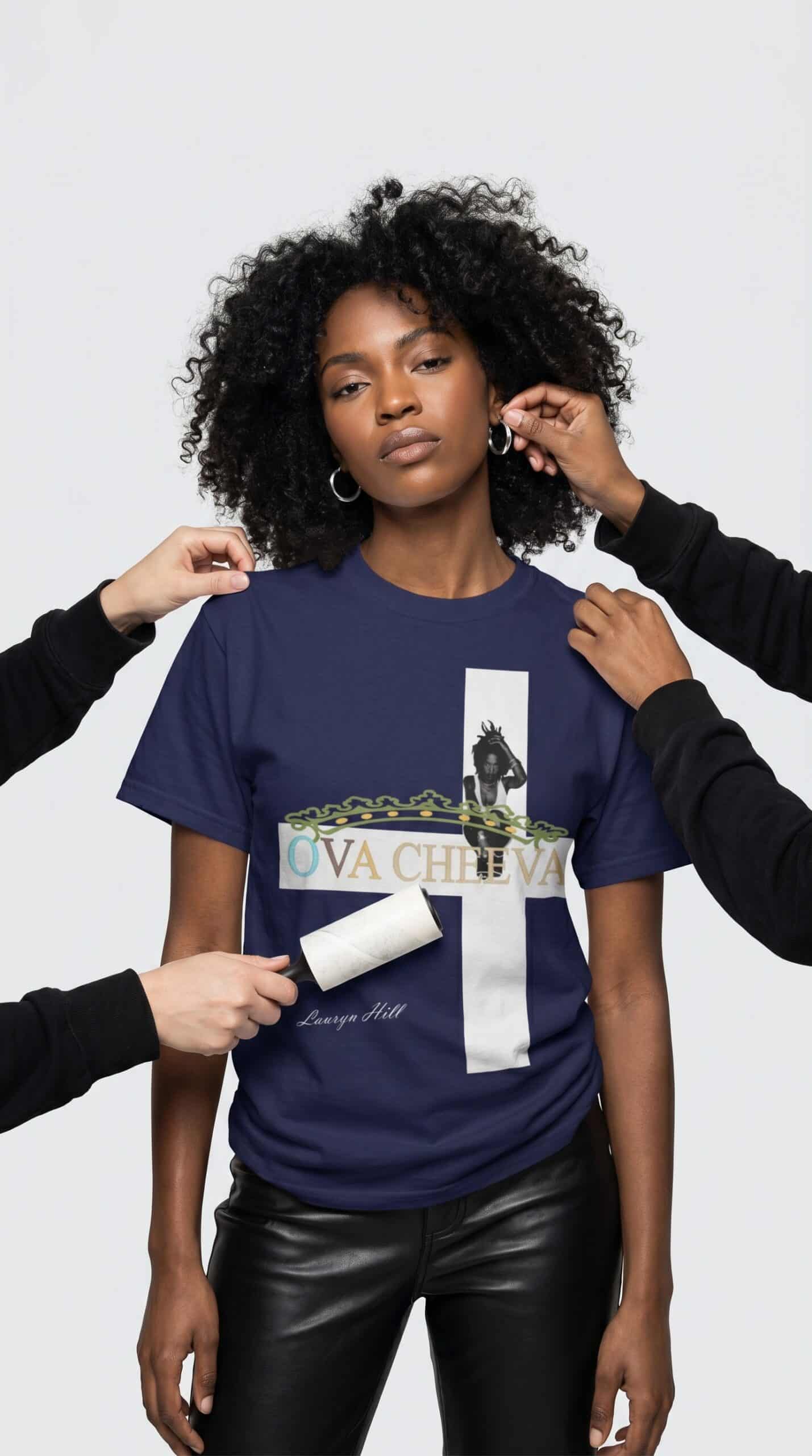 A woman with natural curly hair wearing a blue graphic T-shirt and black leather pants, being styled.