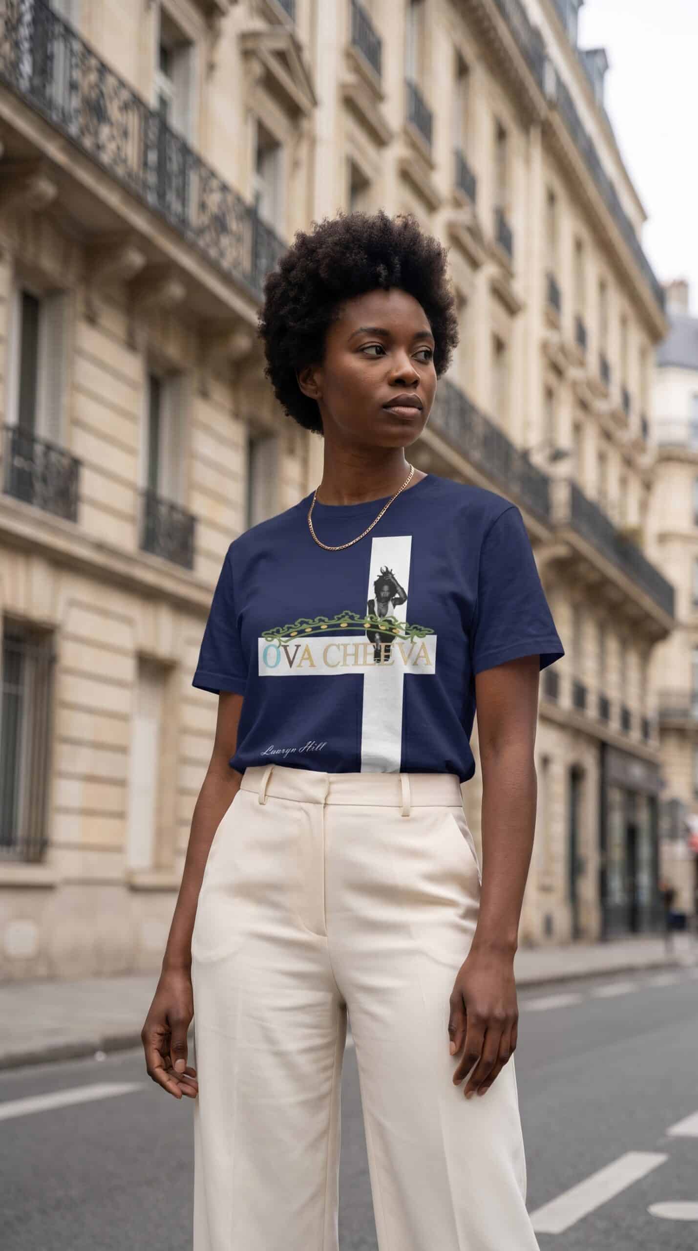A woman with natural hair wearing a Too Dapper urban apparel t-shirt on a city street.