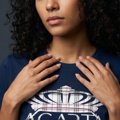 A woman with curly hair wearing a Too Dapper urban apparel t-shirt.