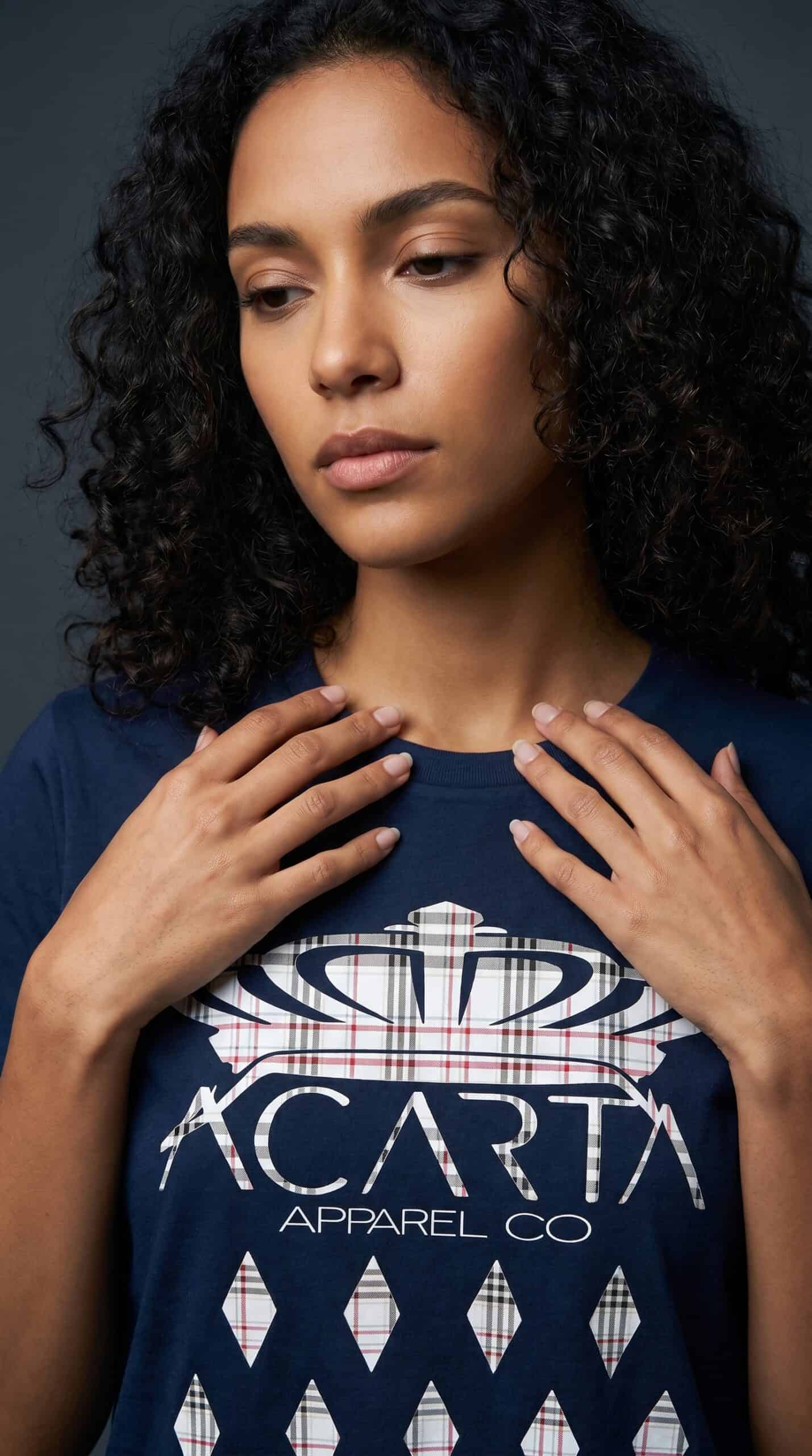 A woman with curly hair wearing a Too Dapper urban apparel t-shirt.