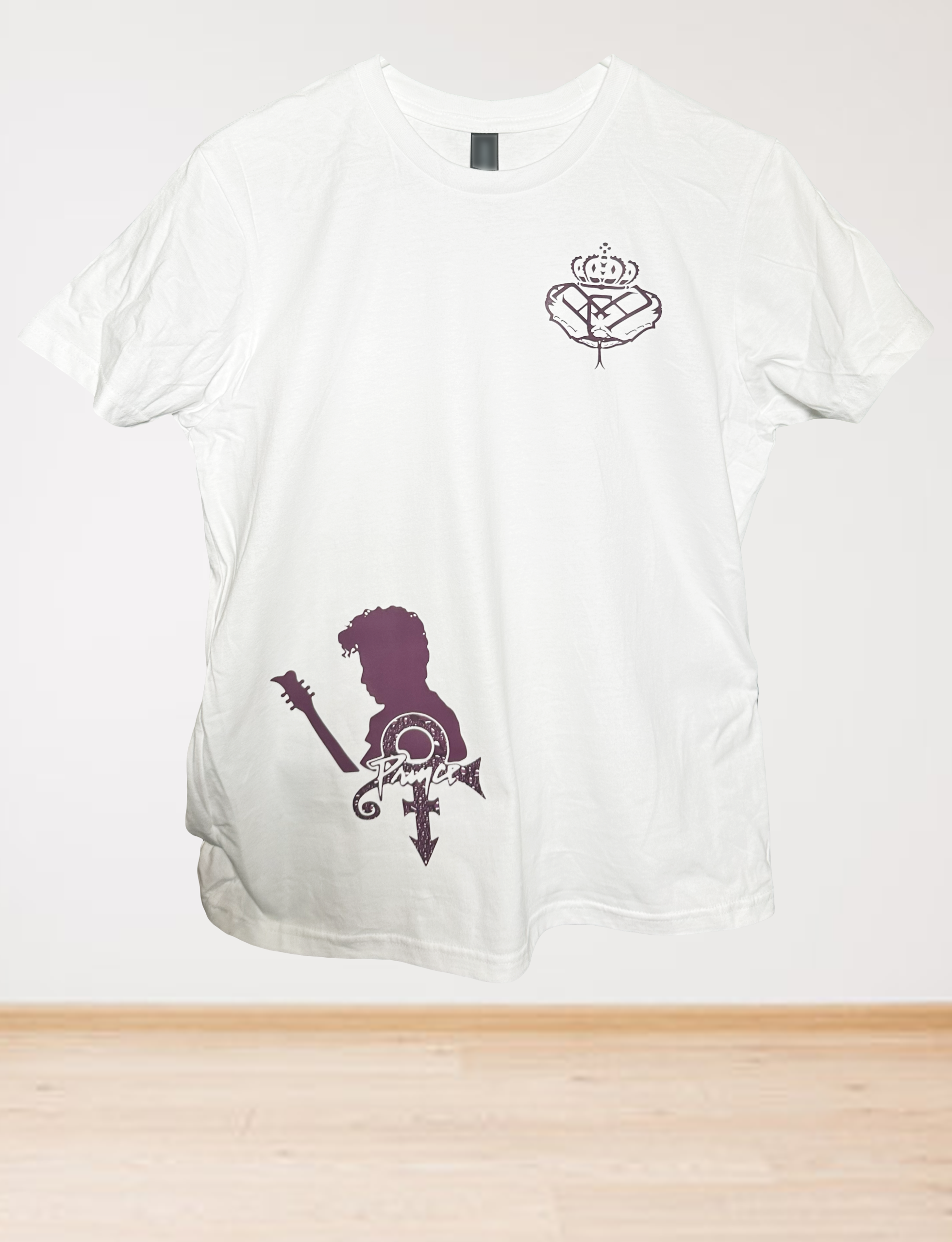 The Womens Midweight Cotton Revolution Line T-Shirt features a small crowned heart on the chest and a large purple silhouette of a guitarist with a stylized symbol near the hem, displayed against a plain background.